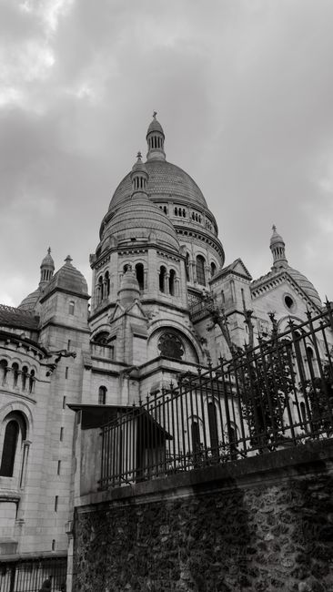 A dramatic black and white photo of the Sacré-Cœur Basilica in Paris, showcasing architectural details.