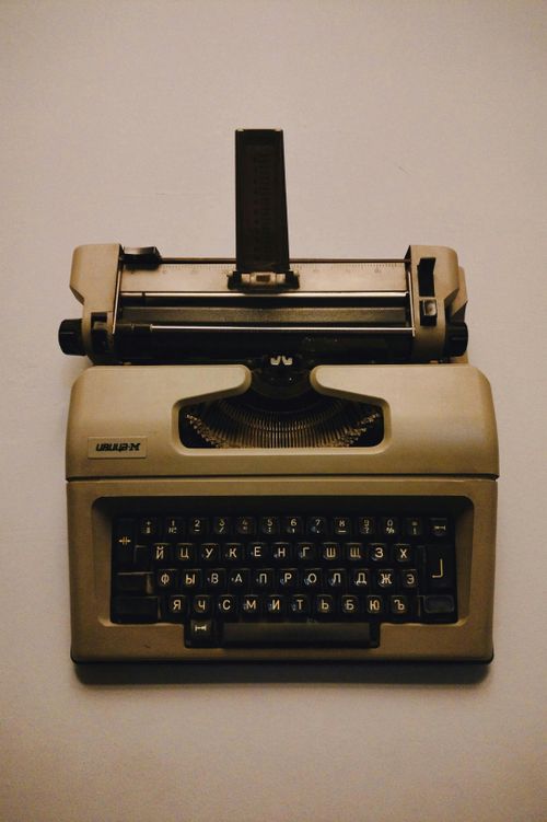 Free Old beige typewriter with Cyrillic keyboard on a neutral background, top view. Stock Photo