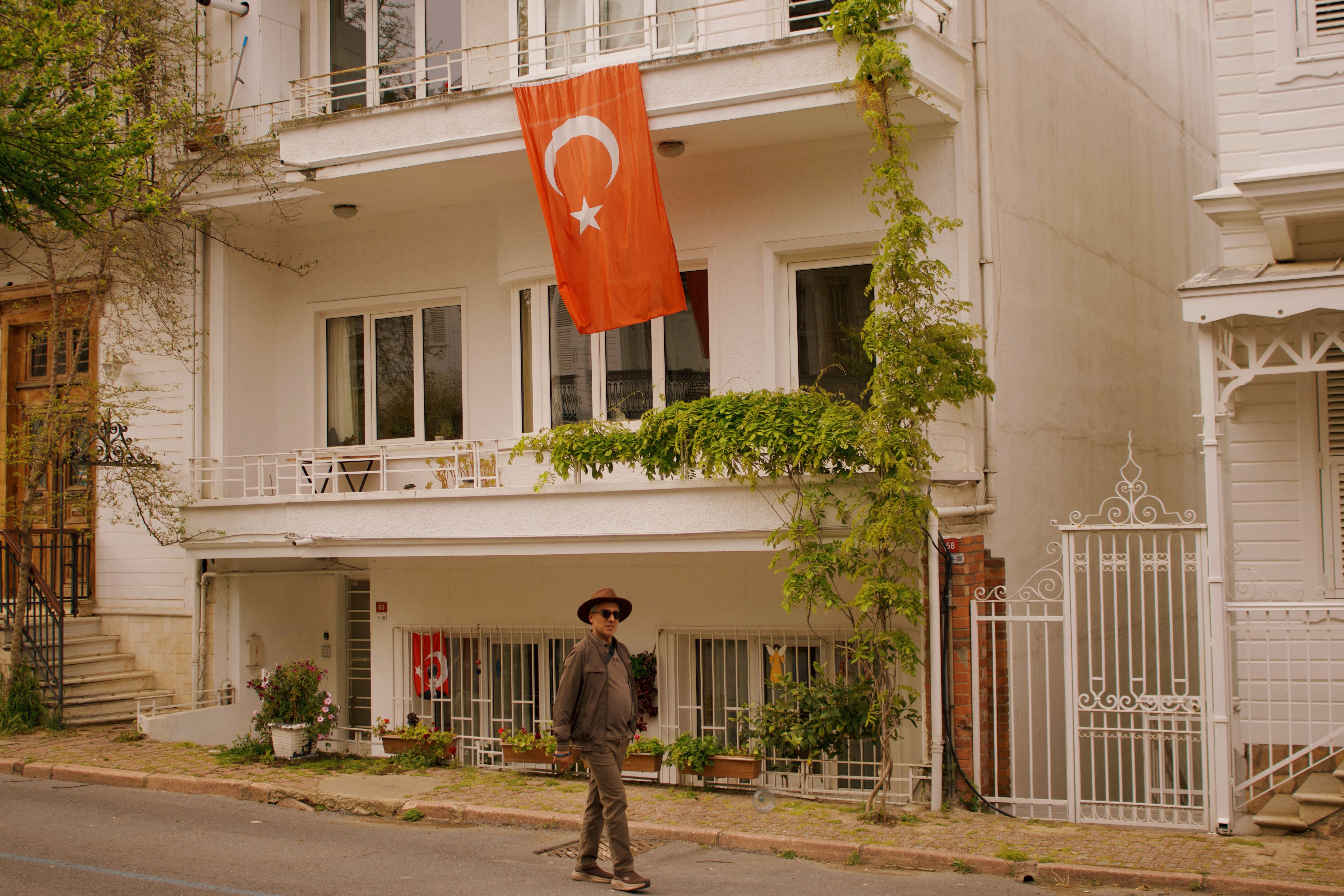 A serene street in Heybeliada, featuring the Turkish flag and beautiful architecture.