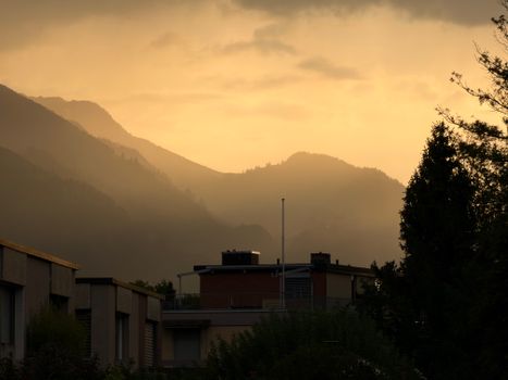 Tranquil mountain landscape with golden hues of sunset over the Swiss Alps.