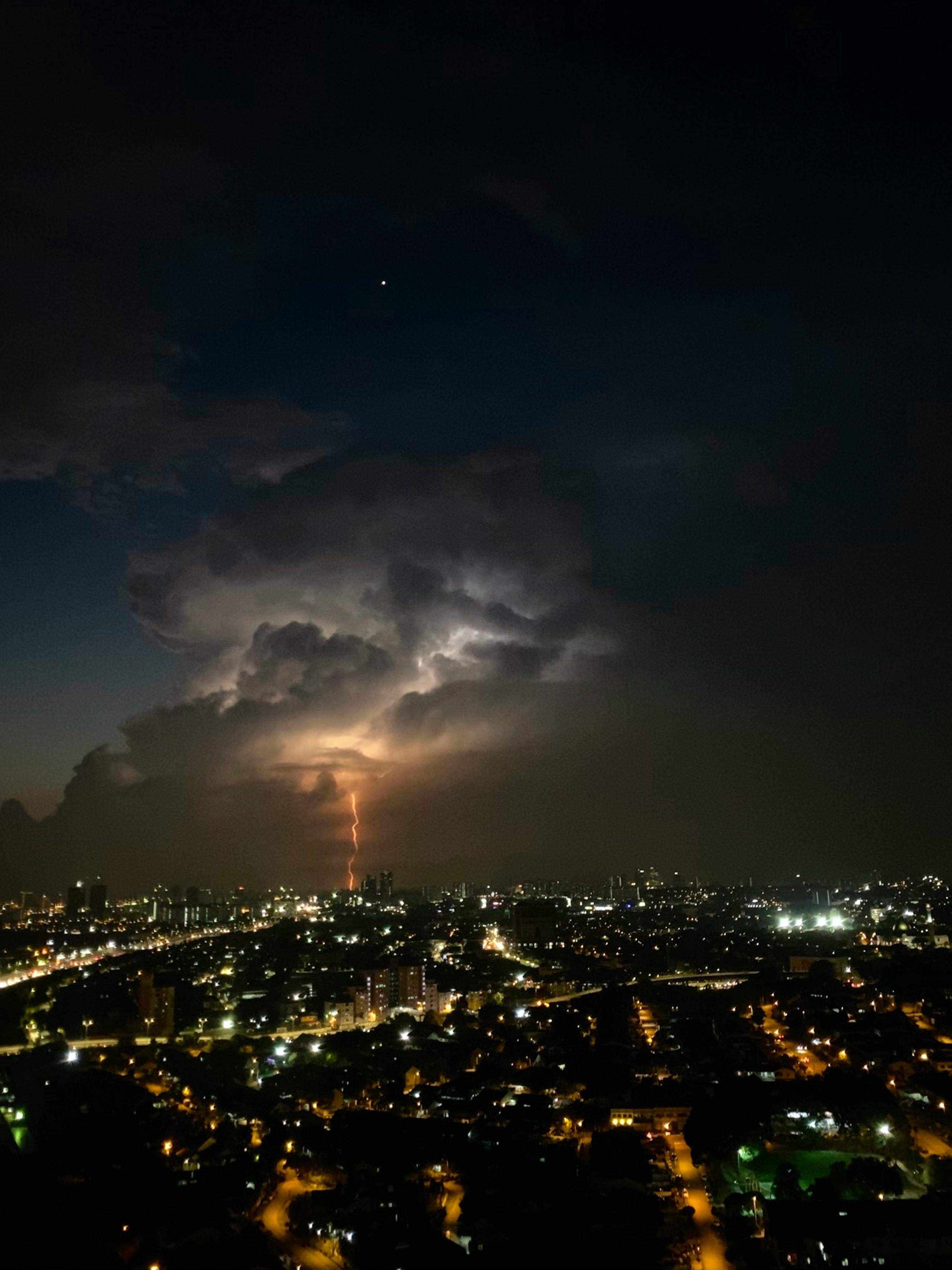 A vivid lightning strike over Kuala Lumpur cityscape during a dramatic night storm.