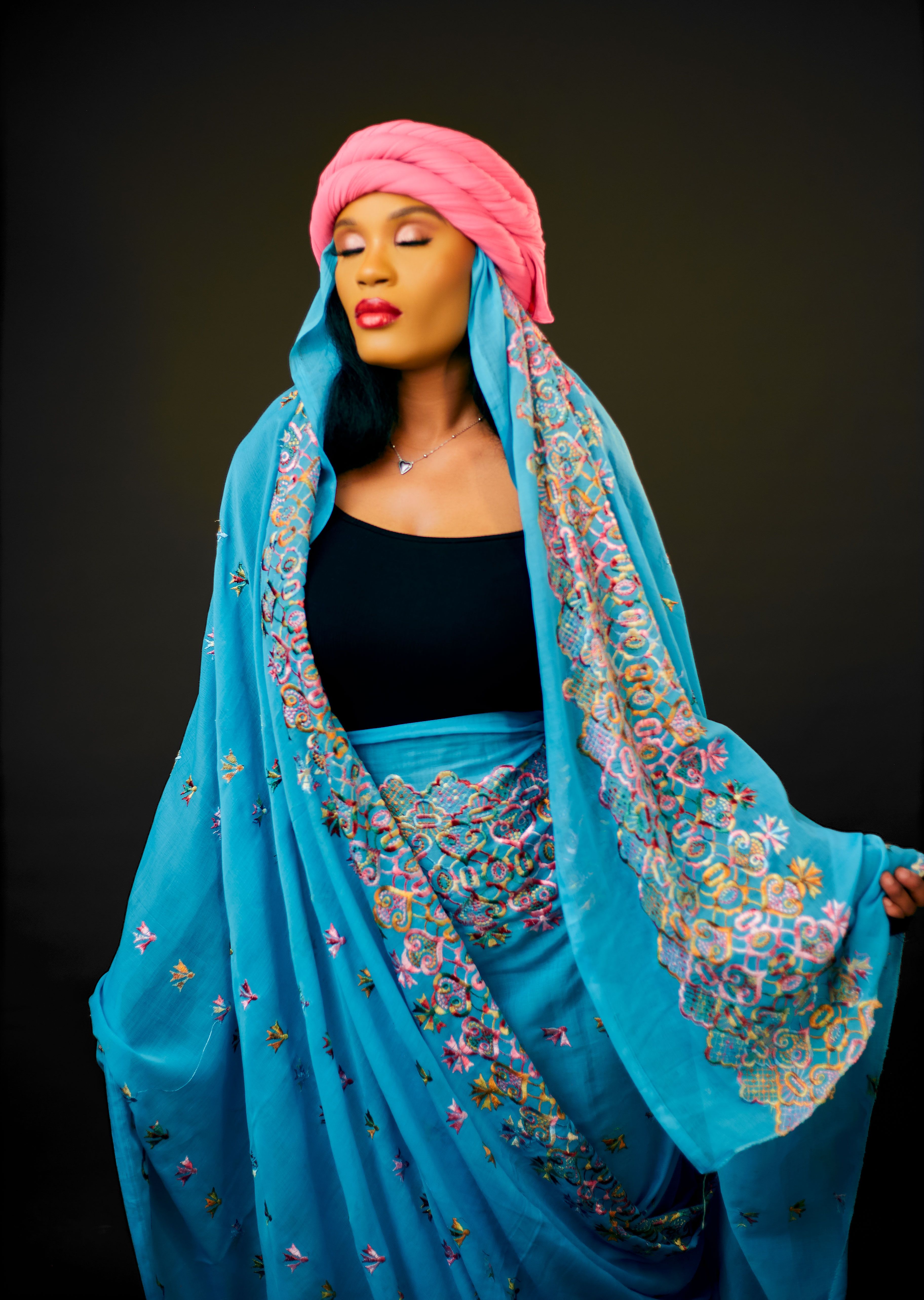 Portrait of an elegant woman wearing vibrant traditional attire with intricate embroidery.