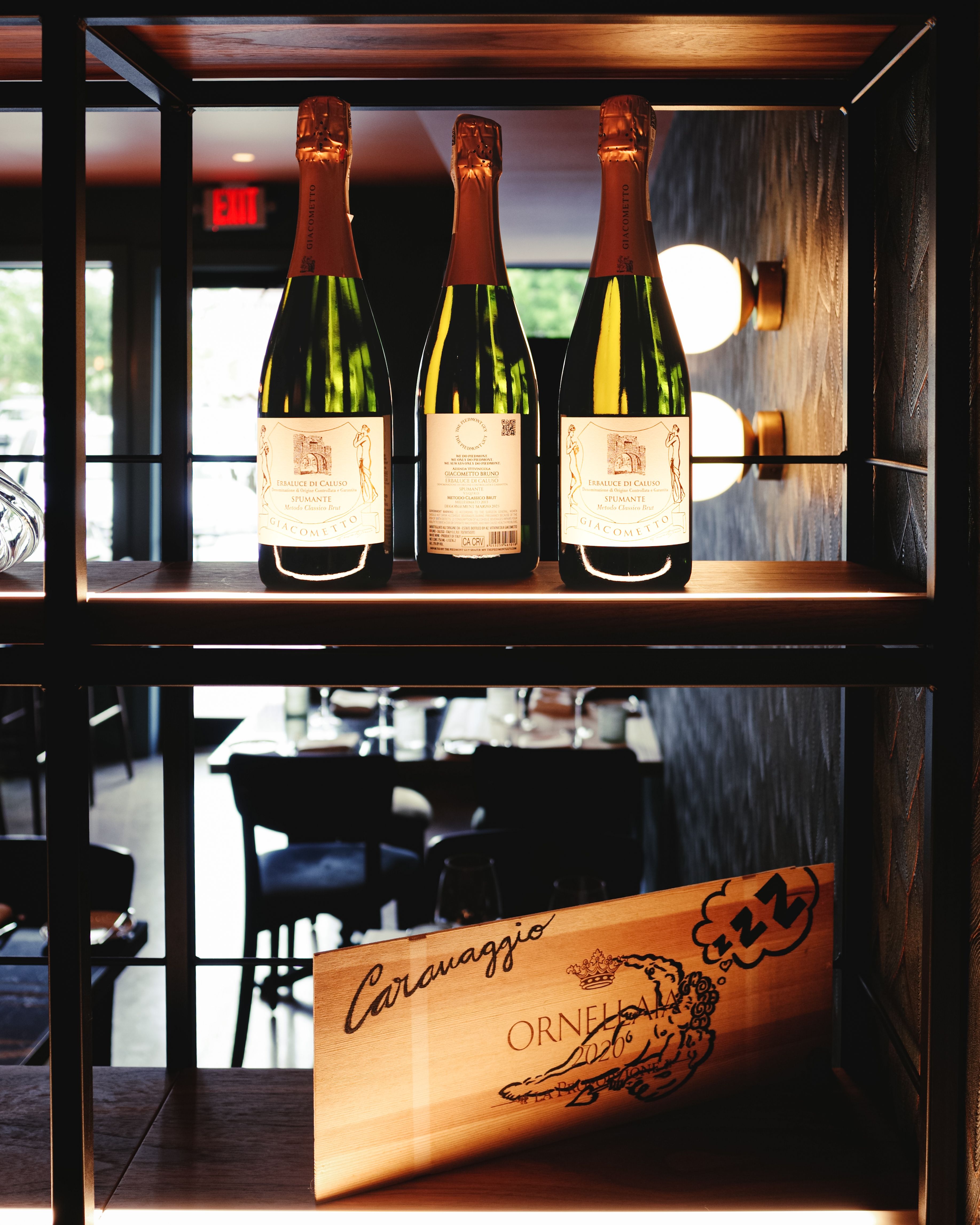 Elegant wine bottles on display in a stylish Houston restaurant interior.