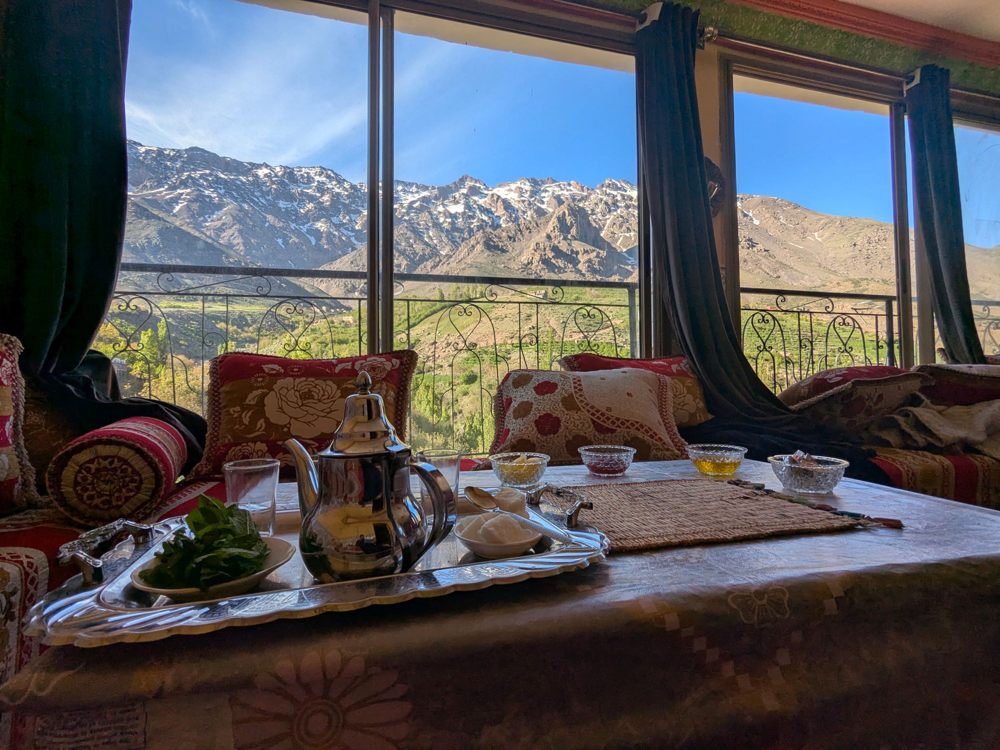Traditional Moroccan tea set with stunning view of the Atlas Mountains from Tachdirt, Morocco.