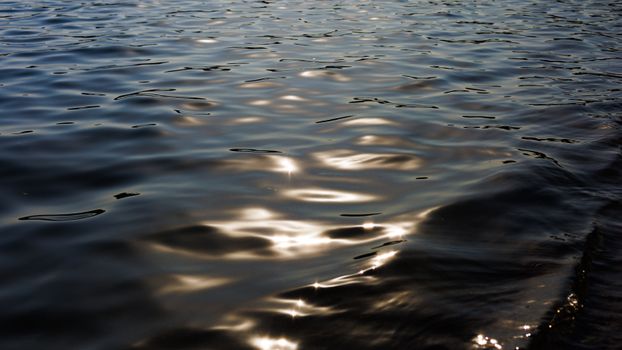 Calming view of sunlight reflecting on rippling water, creating a serene and peaceful atmosphere.