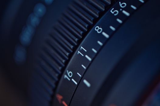 Detailed focus on a camera lens aperture ring, capturing f-stop numbers.