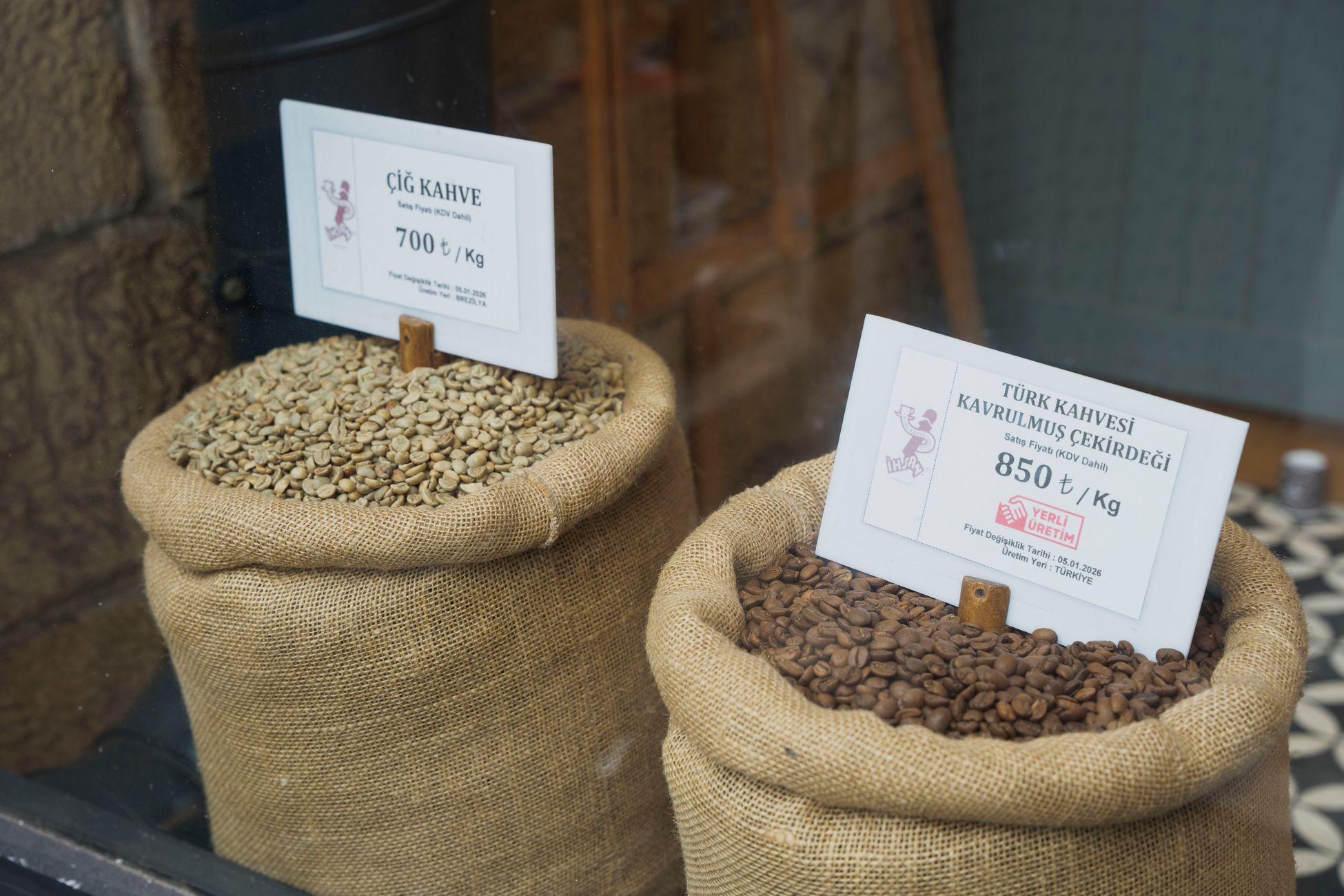 Two burlap sacks of Turkish coffee beans with labels in a shop display.