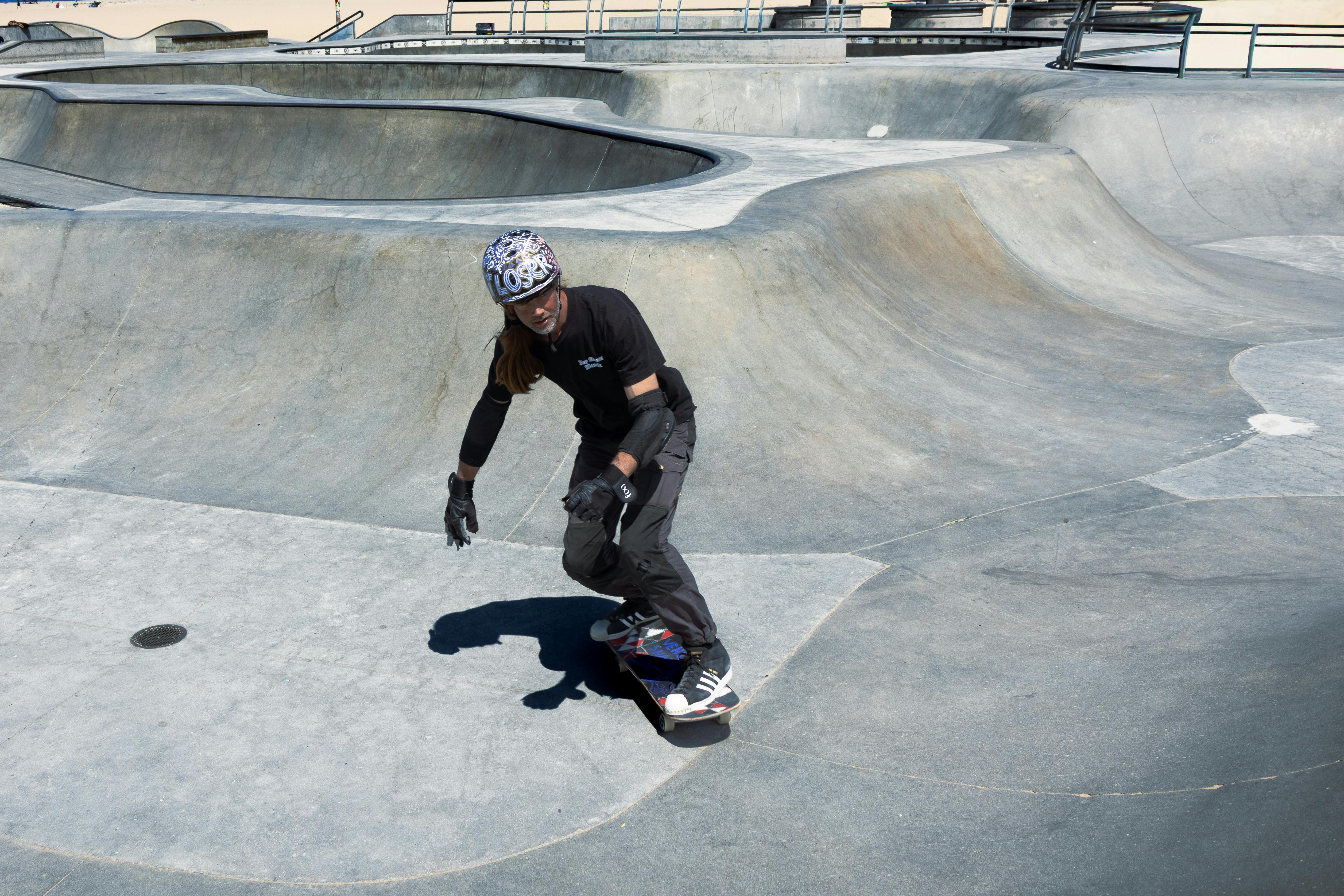 Skateboarder riding with skill at a Los Angeles skatepark. Captured in bright daylight, showcasing energy and movement.