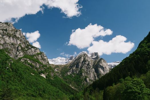 Gorgeous view of the Italian Alps in Lombardia with lush greenery and snow-capped peaks.