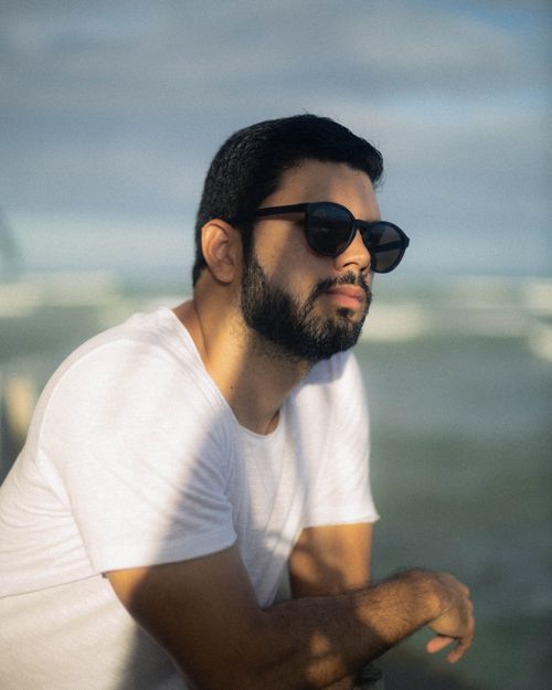 Free A man in sunglasses enjoying a sunny day at the beach. Casual summer vibe. Stock Photo