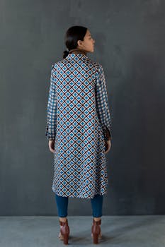 后视图中，一个女人穿着一件时尚的蓝棕色图案外套