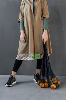 这件时尚服装配有风衣和运动鞋，并附带可重复使用的网袋和水果