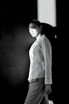 在柔和的灯光下，优雅的黑白肖像描绘了一位时尚女性，展现了时尚与风格