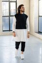 一位留着胡须的时尚男子在室内穿着单色服装