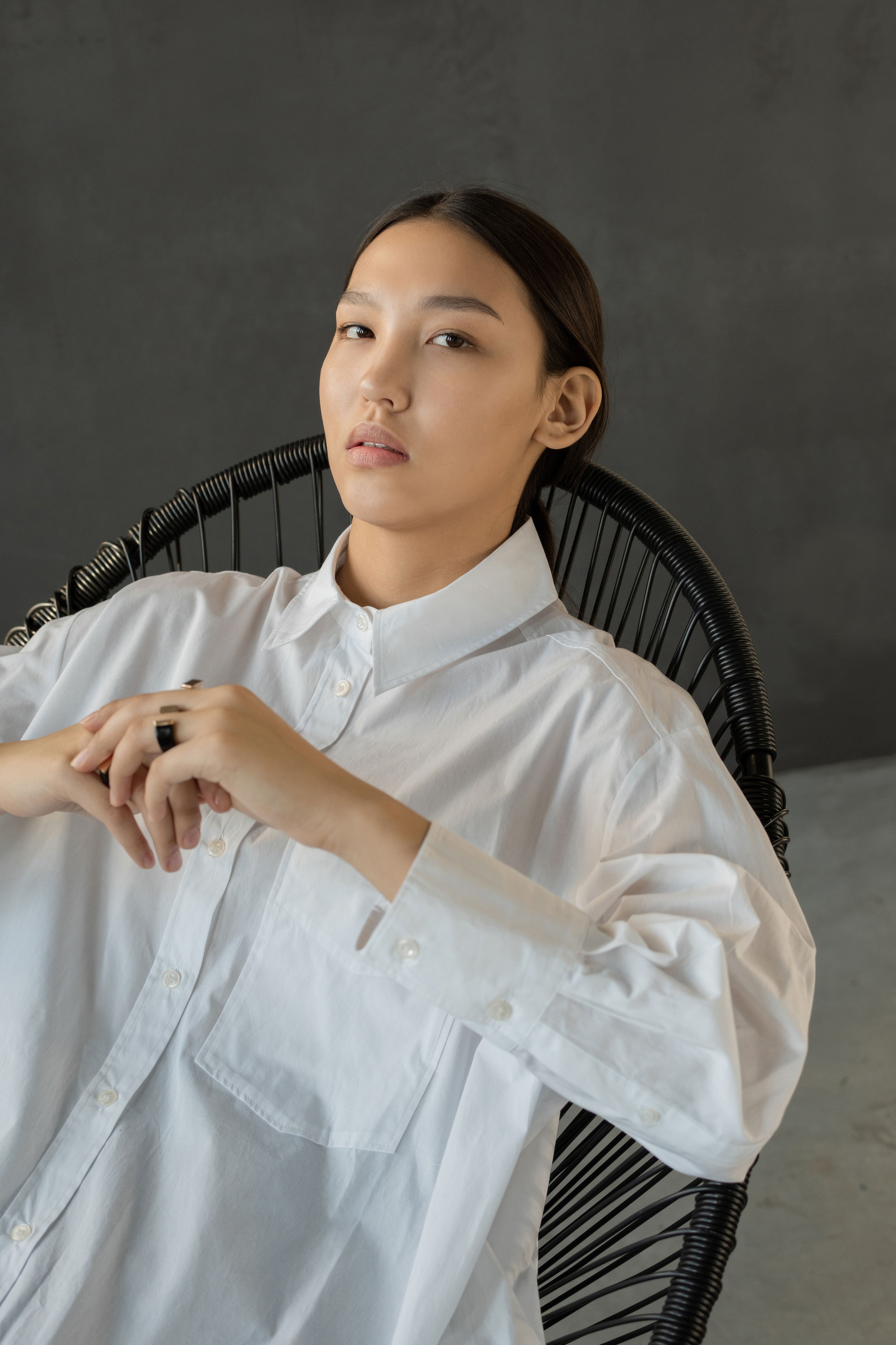 一位时尚女性坐在椅子上，肖像展现出自信的风格与优雅