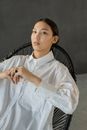 一位时尚女性坐在椅子上，肖像展现出自信的风格与优雅