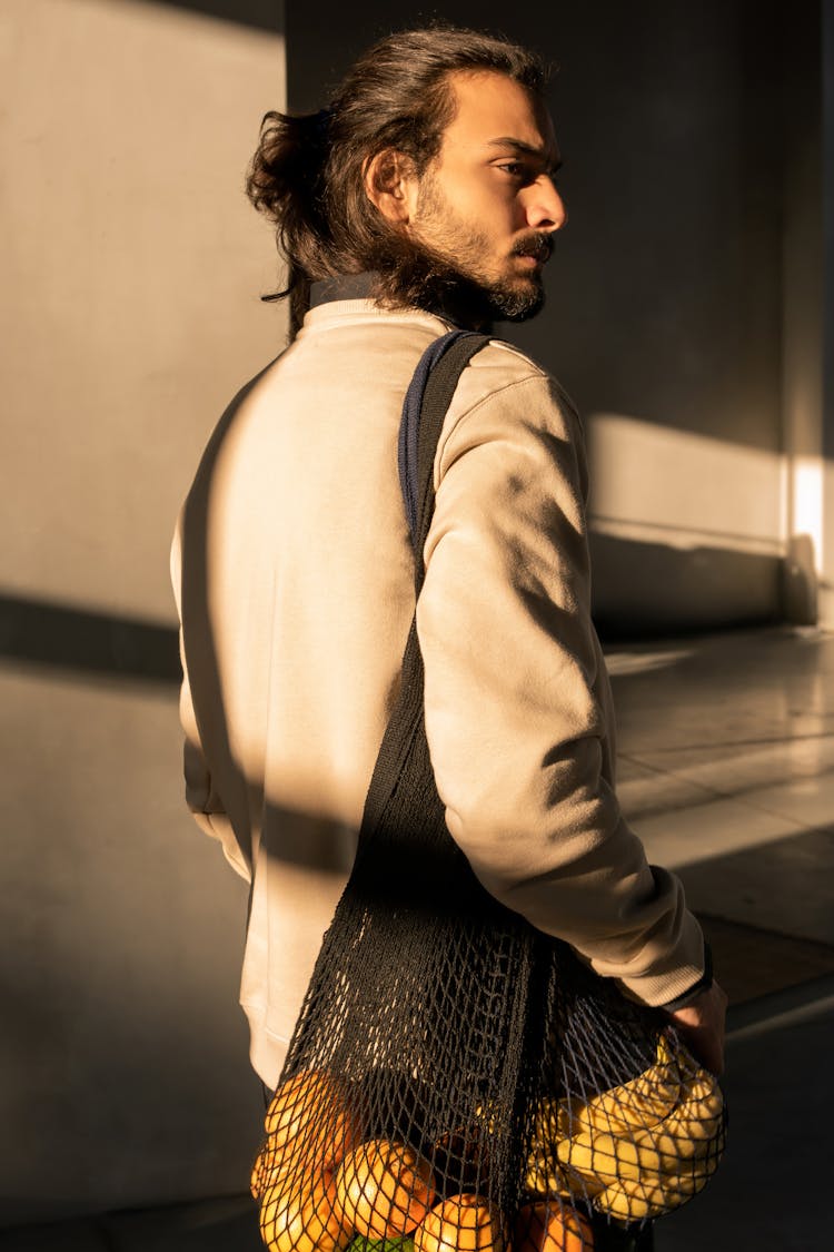 Man Carrying Bag Of Fruits