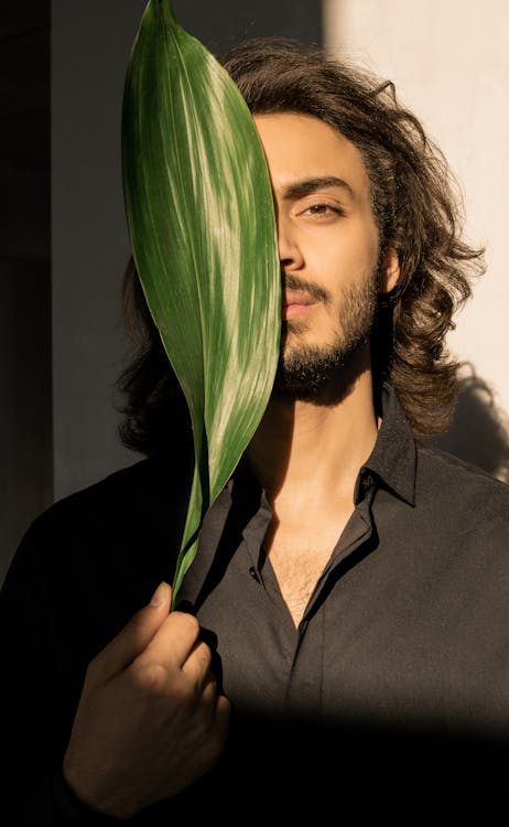 Photo Of Man Covering His Face With Leaf