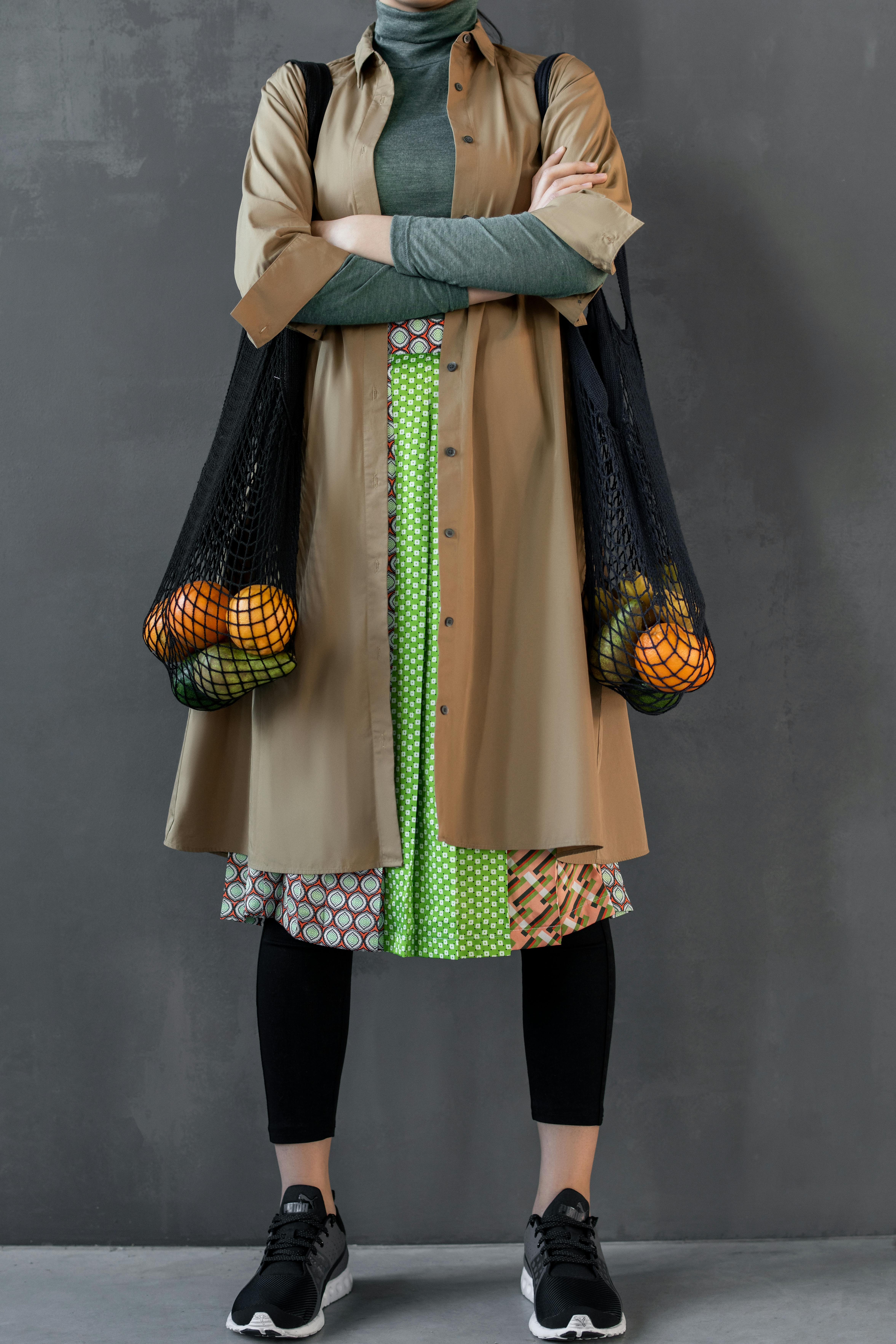 拎着水果网袋、穿着现代服装的时尚女人