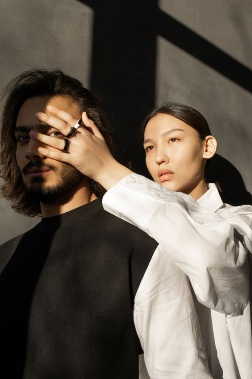 Free A striking portrait of a couple in dramatic lighting, exploring modern fashion and expression. Stock Photo