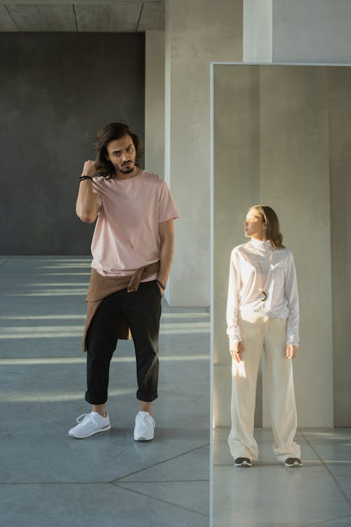 Homme En Chemise Boutonnée Rose Et Pantalon Noir Debout Sur Le Sol Bleu