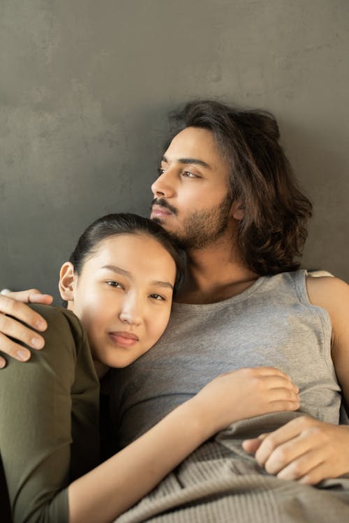 Man in Gray Tank Top Hugging Woman in Gray Tank Top