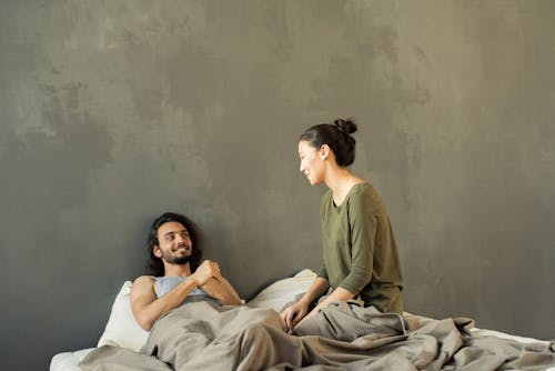 Femme En Chemise à Manches Longues Verte Et Débardeur Gris Allongé Sur Le Lit