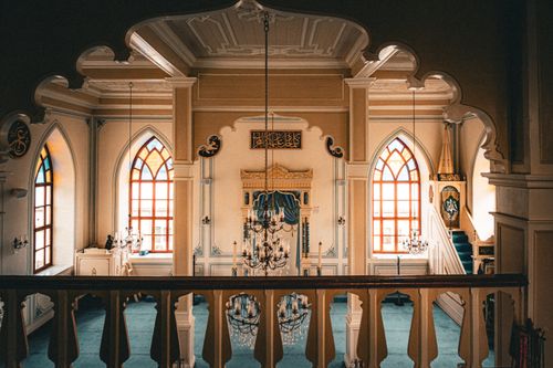 Free View of a beautifully designed mosque interior featuring stained glass windows and chandeliers. Stock Photo