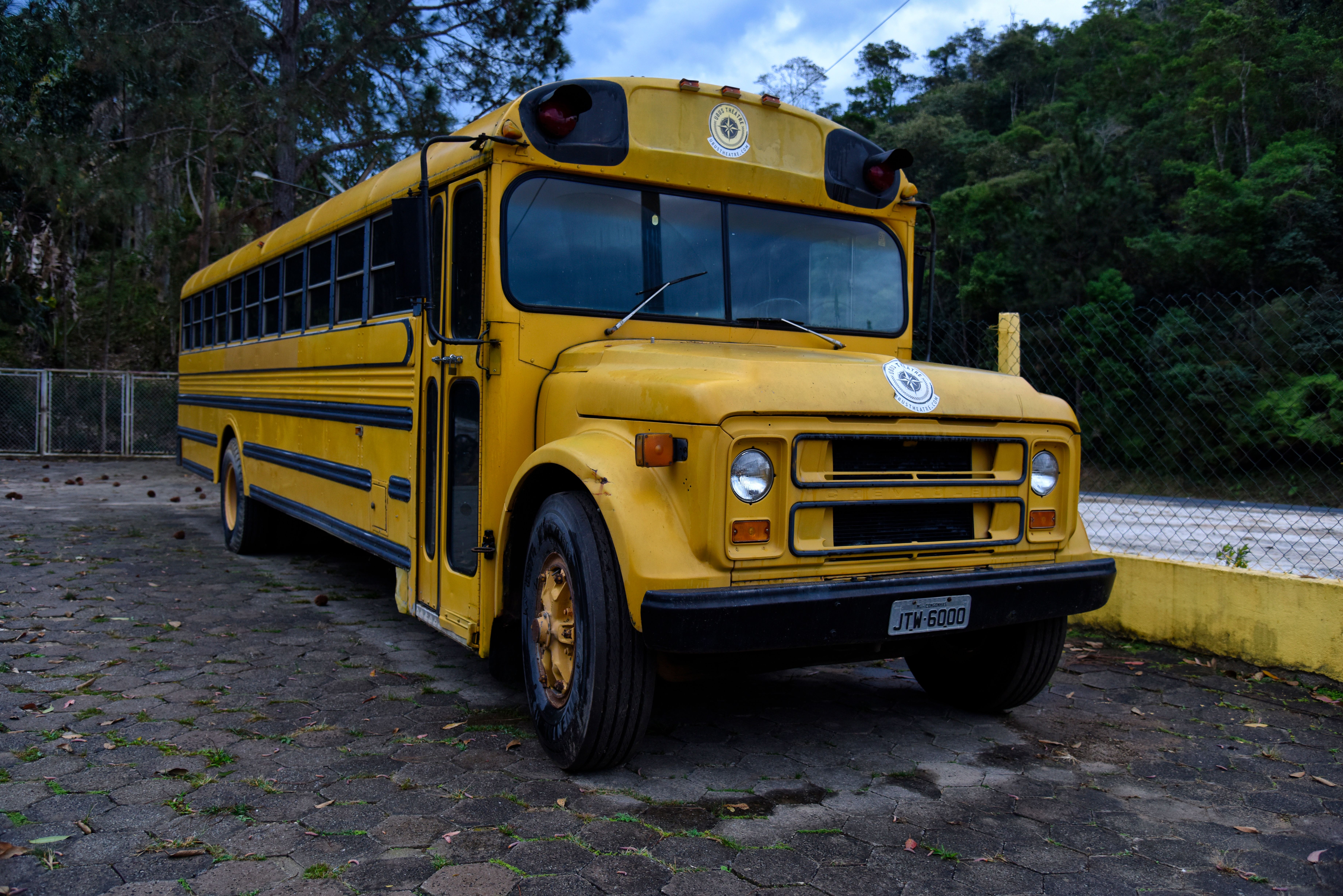 Classic yellow school bus parked in a scenic outdoor area of Ubatuba, São Paulo, Brazil.