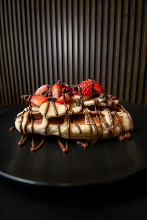 Free Irresistible waffle topped with fresh strawberries, bananas, and chocolate chips, perfect for a sweet indulgence. Stock Photo