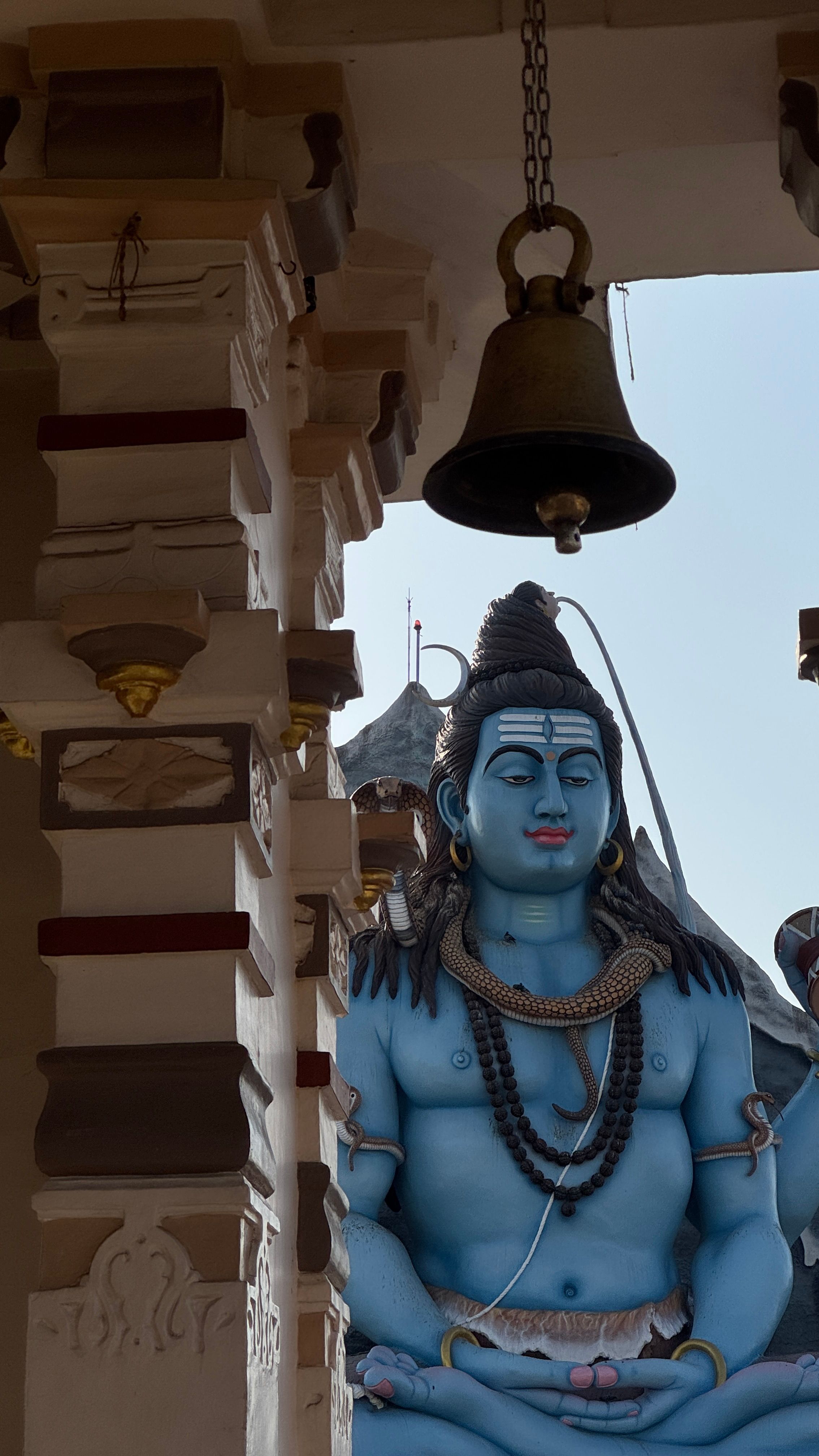 A peaceful view of a Shiva statue in a temple setting in Surat, India.