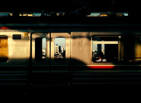 Dramatic view of a city through a train window during twilight, featuring a solitary passenger.