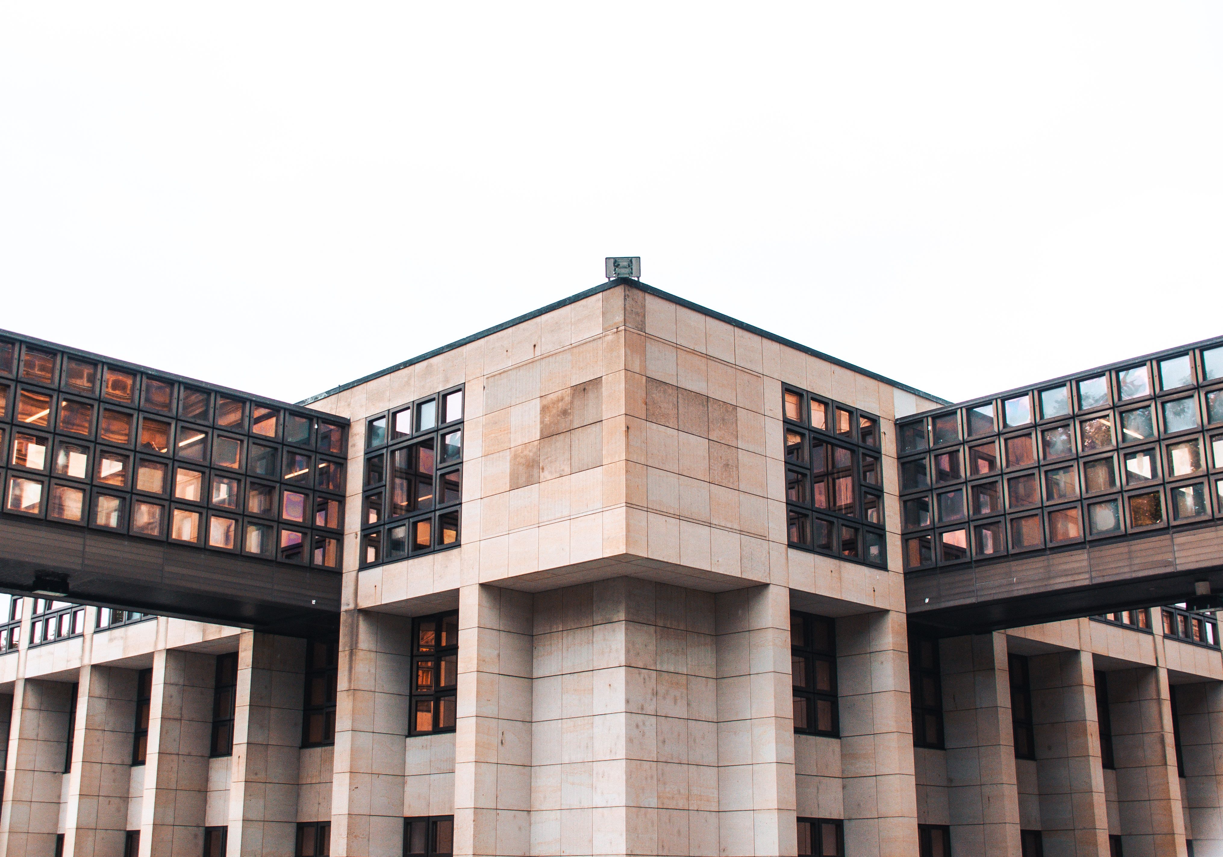 A striking modern building with a glass facade and geometric design elements, showcasing architectural innovation.
