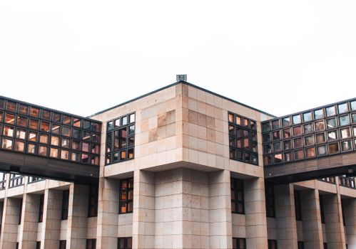 A striking modern building with a glass facade and geometric design elements, showcasing architectural innovation.