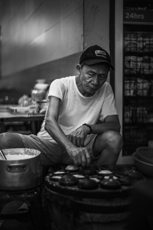 Free A street vendor in Vietnam making traditional Vietnamese desserts on a hot griddle. Stock Photo