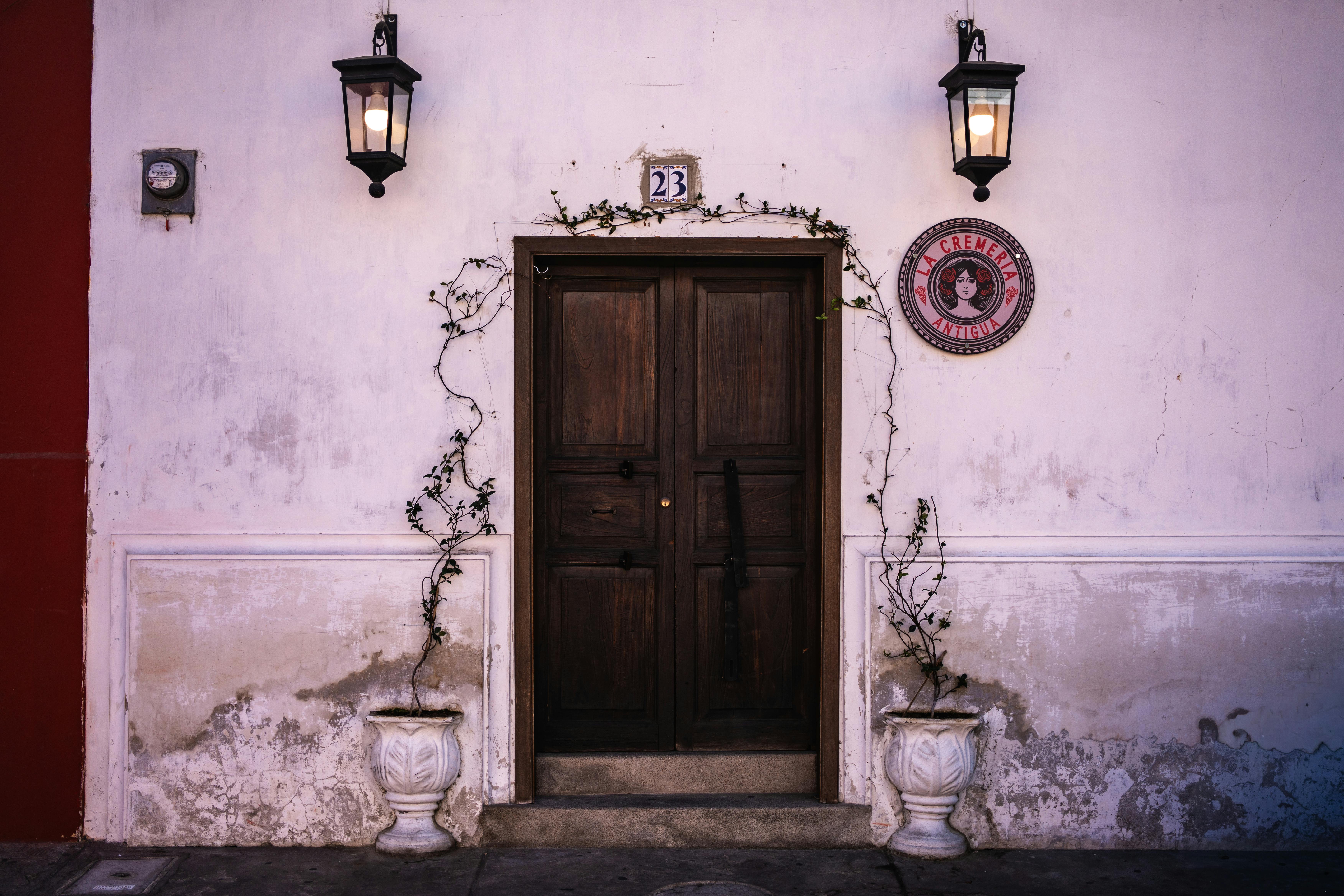 A charming rustic doorway adorned with plants in Antigua Guatemala, capturing classic colonial architecture.