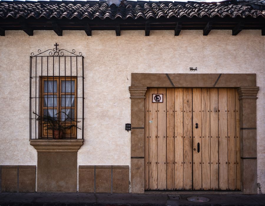 A whitewashed adobe facade with a heavy wooden door