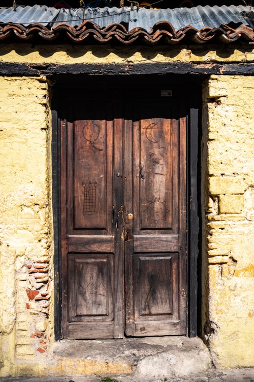 Free A vintage wooden doorway framed by textured yellow bricks in Antigua Guatemala, revealing colonial charm. Stock Photo