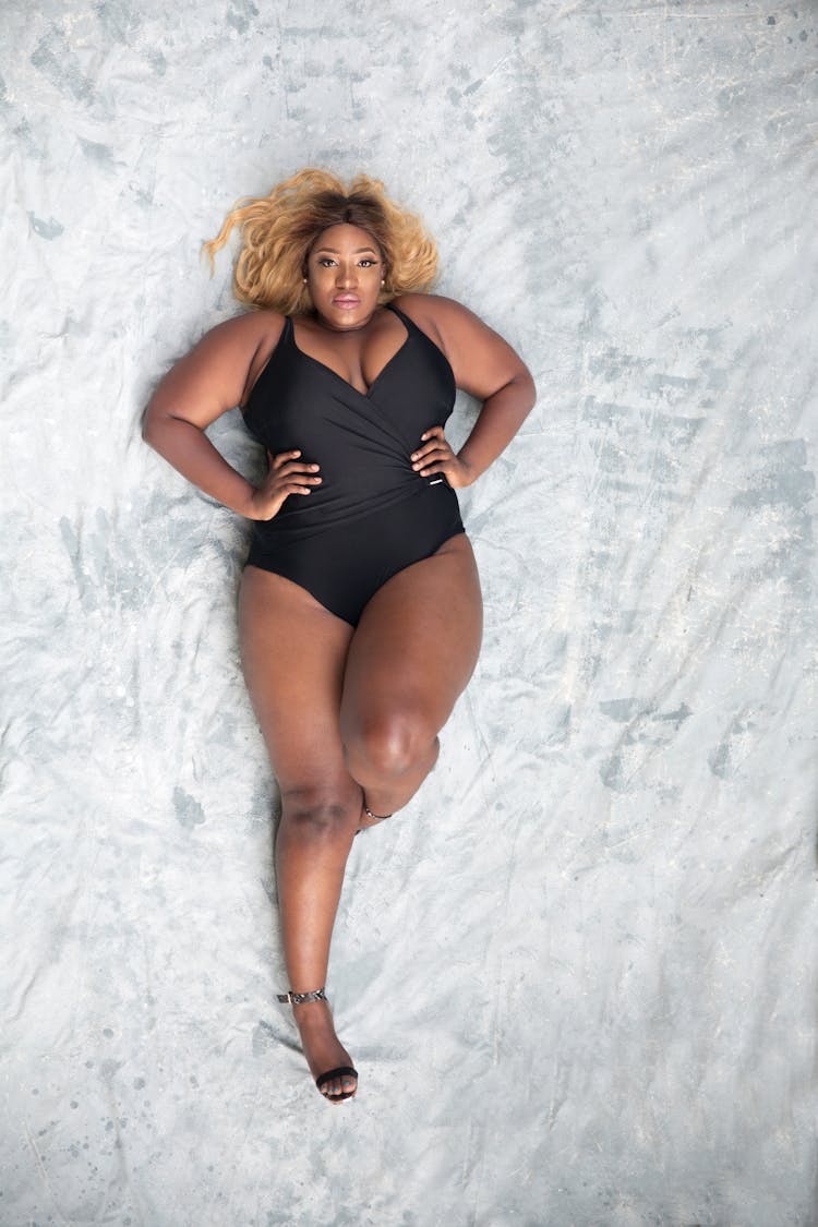 Overhead Photo Of Woman In Black One Piece Swimsuit Lying Down On The Floor