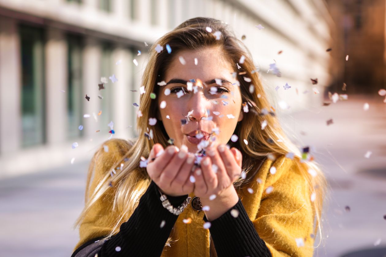 Guest blowing confetti while celebrating in the Snapwhirl photo booth