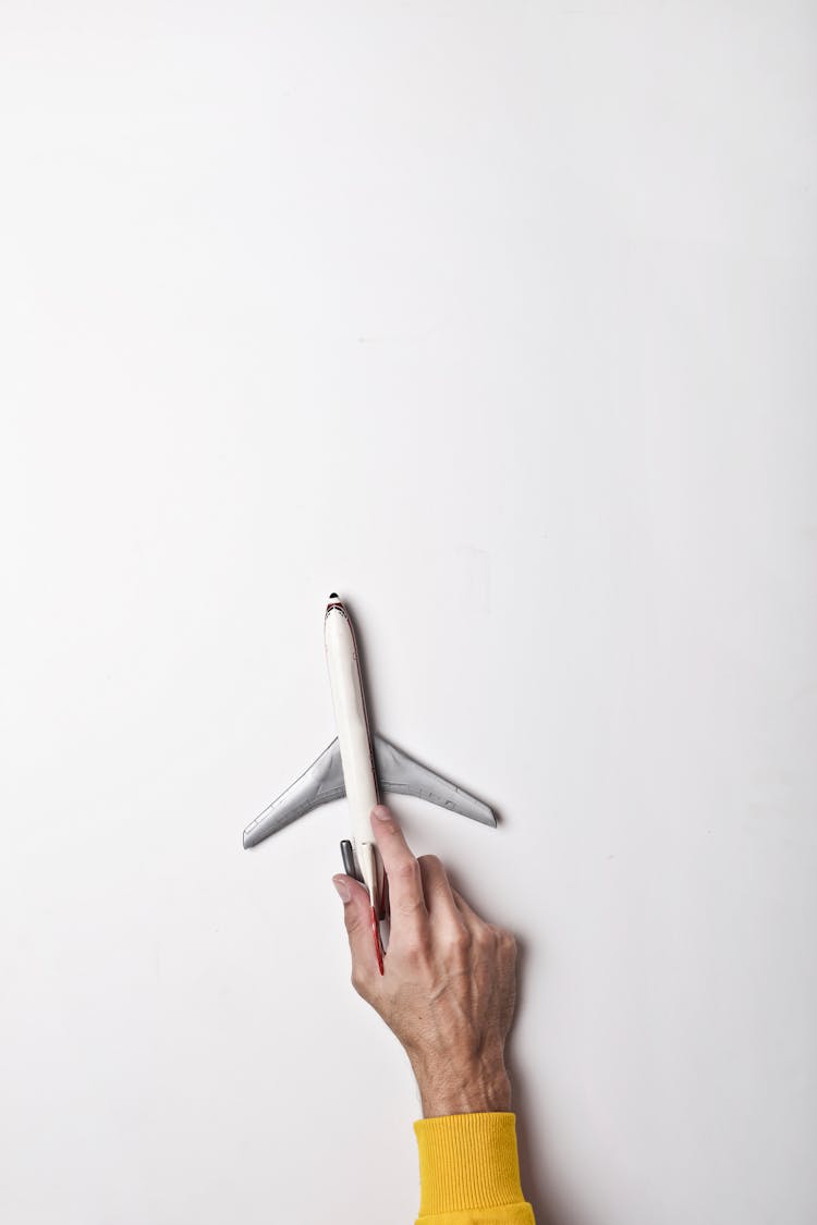 Male Hand With White Toy Plane