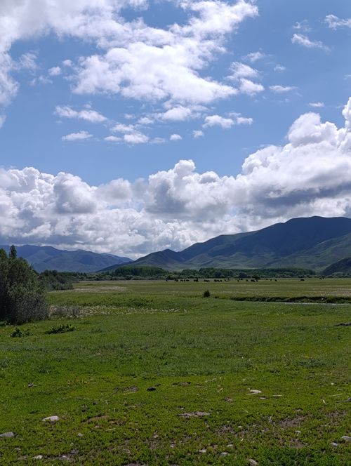 Free Serene landscape with mountains, blue sky, and clouds, perfect for nature lovers. Stock Photo