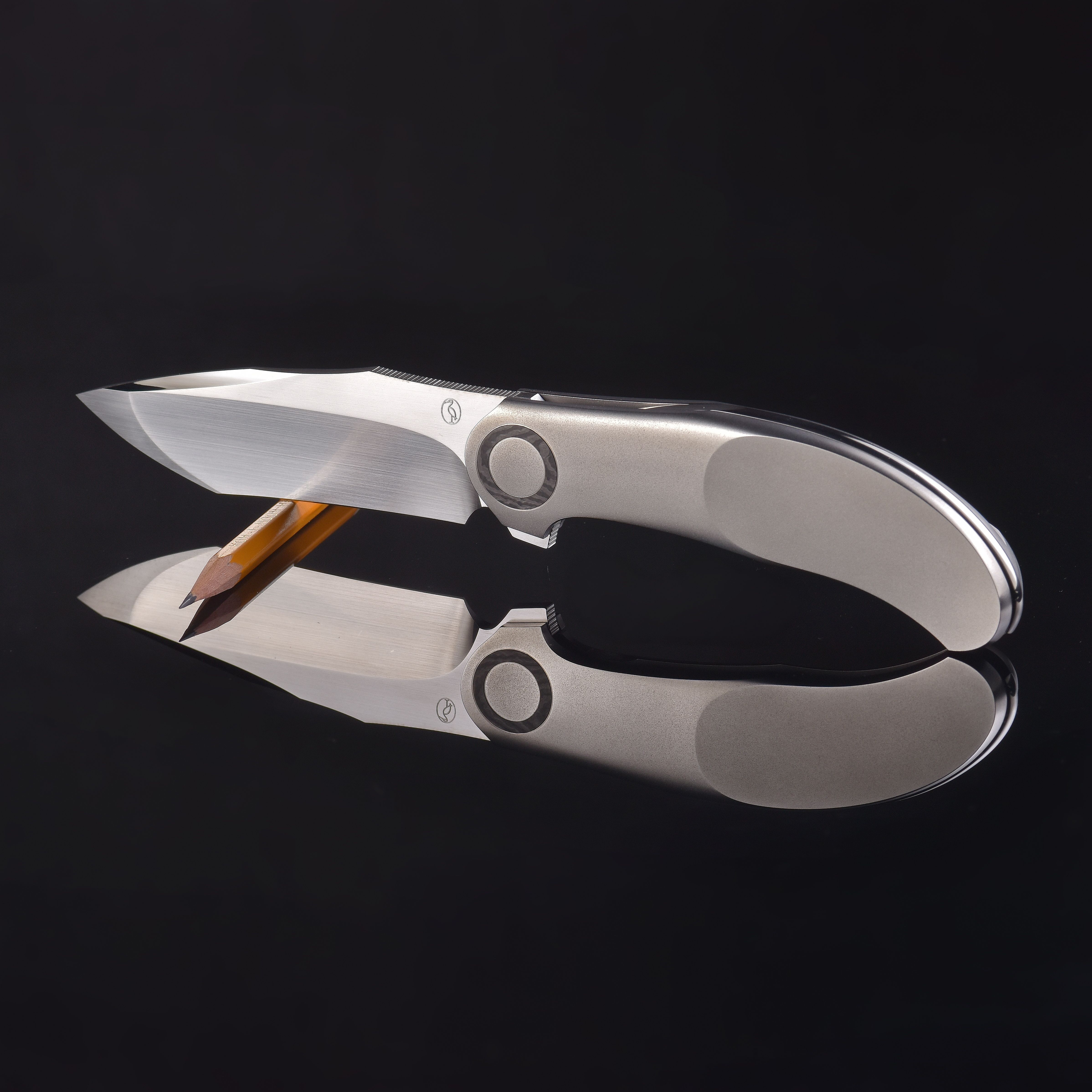 Elegant photo of scissors and pencil with reflection on glossy black surface, showing artistic design and symmetry.