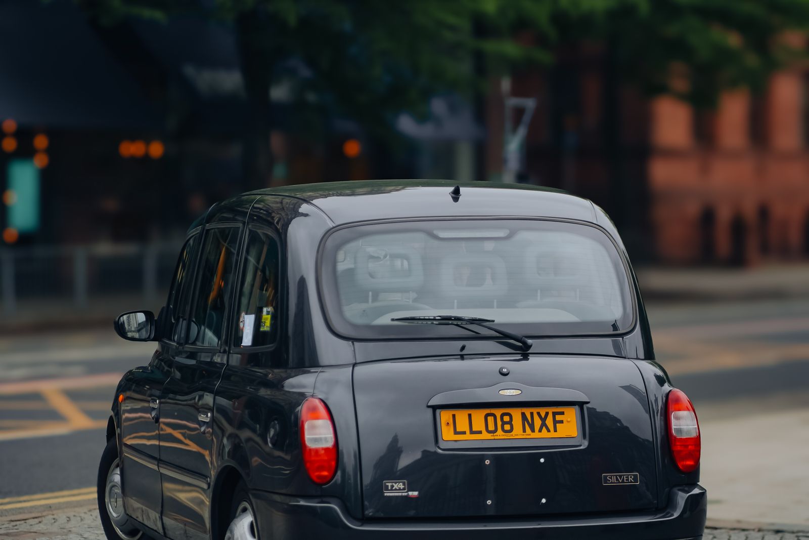 Kruze taxi dropping a student at a school gate in Leeds, West Yorkshire