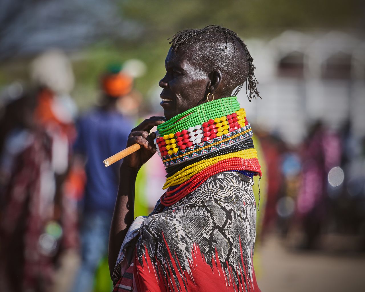 a striking image of a woman wearing colorful traditional beaded neckwe