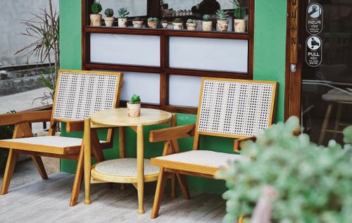 Free Outdoor cafe seating in Ben Tre, Vietnam, featuring wooden chairs and table. Stock Photo