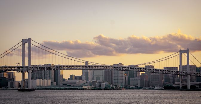 Spectacular view of Tokyo's skyline and bridge at sunset over Tokyo Bay, capturing the serene atmosphere.