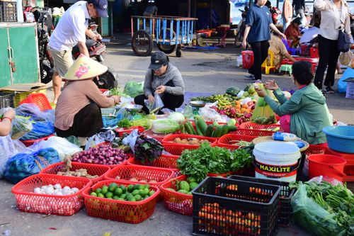 Free A lively Asian market scene featuring fresh vegetables and local vendors engaged in trade. Stock Photo