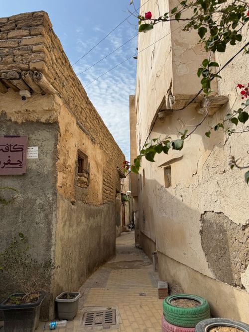 Free Charming narrow alley between rustic buildings and plants in a historic village setting. Stock Photo