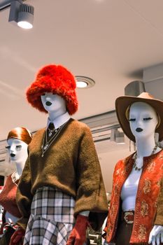 Stylish mannequins showcasing trendy winter outfits and accessories in a retail store display.